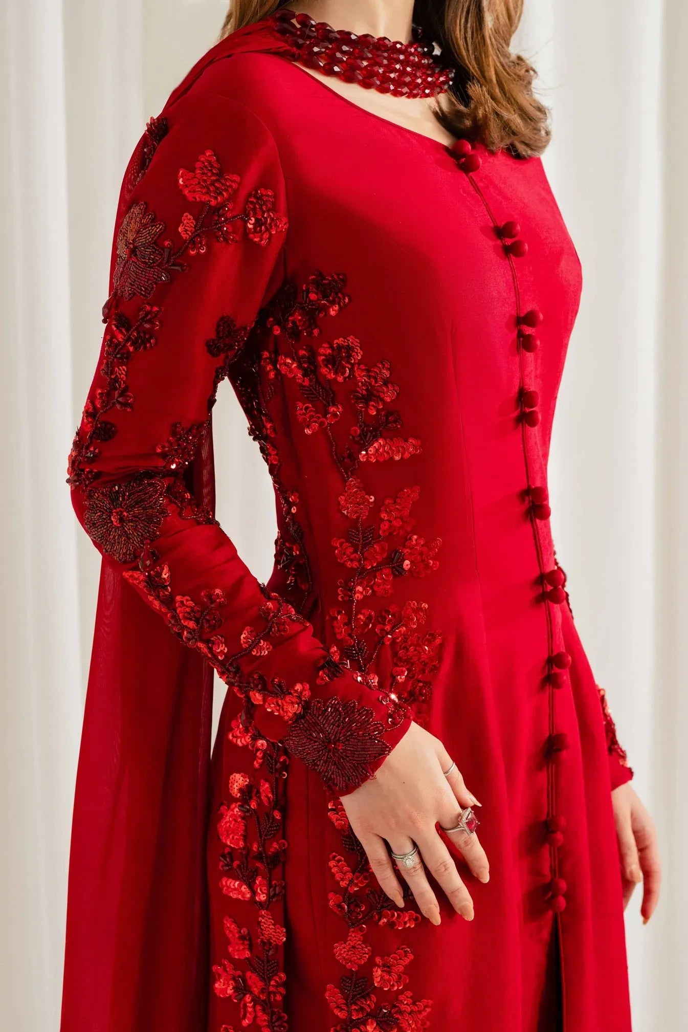 Detail shot of hand embroidery and covered buttons on Rungish red formal kurta